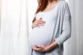 Těhotná žena dotýkající se břicha