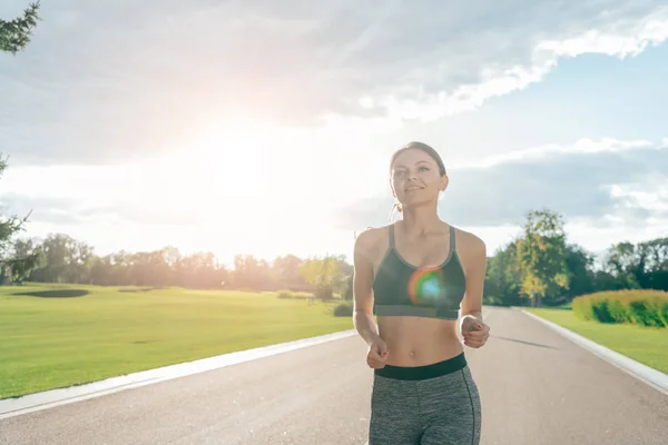 Donna sorridente che corre nel parco — Foto Stock