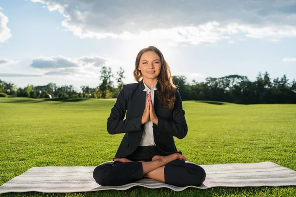 Empresária meditando no parque — Fotografia de Stock