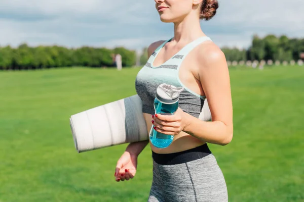 Жінка з йоги килимок і пляшка води — стокове фото