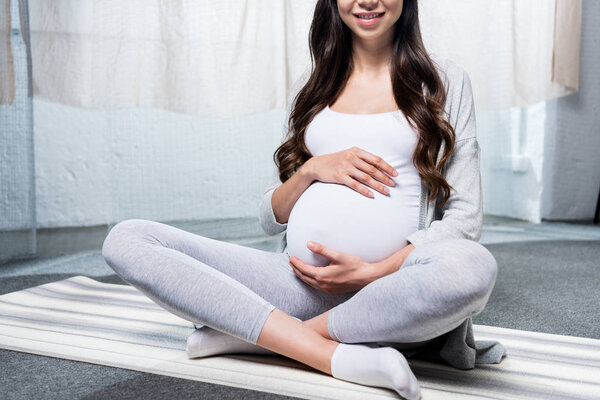 Pregnant woman sitting in lotus pose