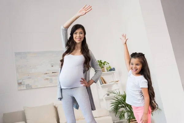 Kobieta w ciąży i córka wykonywania — Zdjęcie stockowe