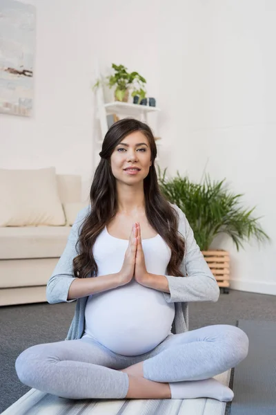 Pregnant woman in lotus pose — Free Stock Photo