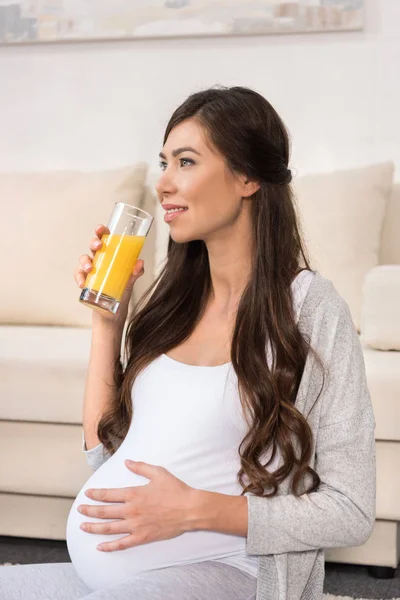 Mulher grávida bebendo copo de suco — Fotografia de Stock