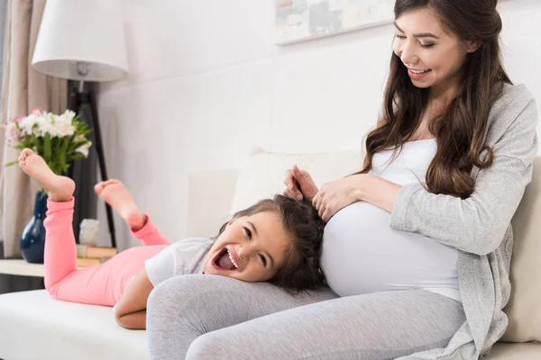 Mulher grávida com filha deitada no colo — Fotografia de Stock