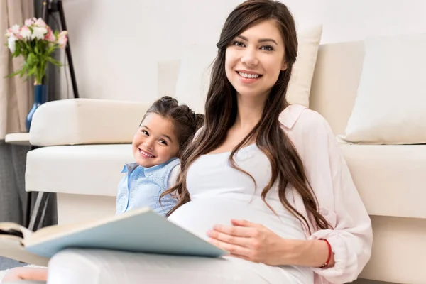 Mädchen und schwangere Mutter lesen Buch — Stockfoto