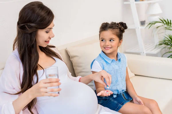 Girl holding out pills to mother — Stock Photo, Image