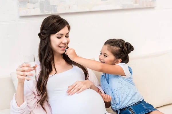 Menina pílula de alimentação para a mãe — Fotografia de Stock