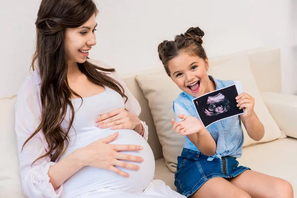 Девушка показывает беременность УЗИ фото — стоковое фото