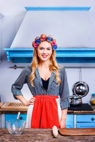 Housewife in apron and curlers — Stock Photo, Image