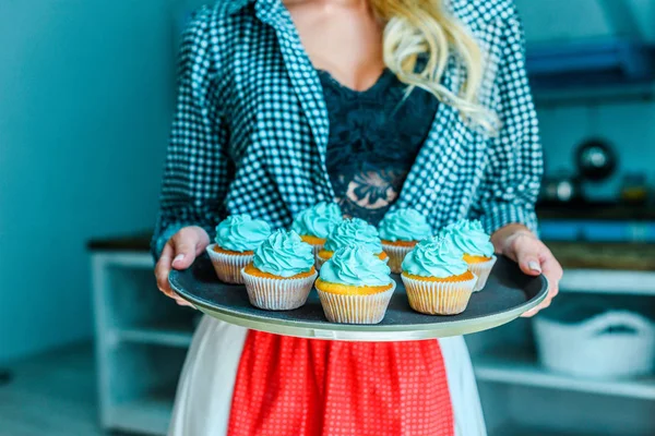 Vrouw in schort met cupcakes — Stockfoto