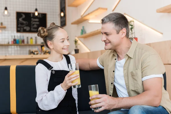 Far och dotter med apelsinjuice — Stockfoto