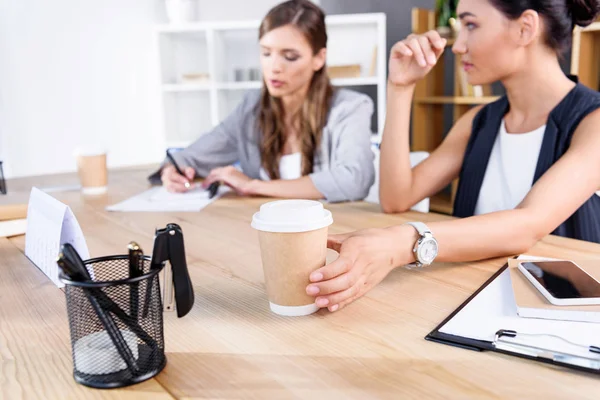 Mulheres de negócios com café no local de trabalho — Fotografia de Stock