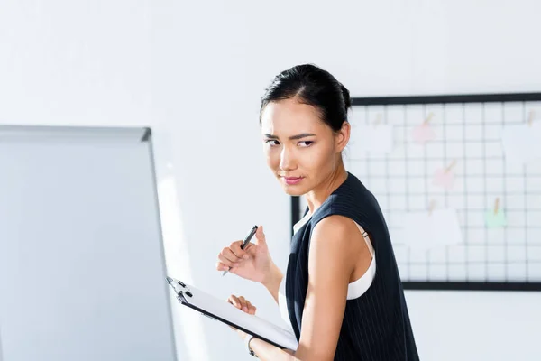 Asian businesswoman with clipboard — Stock Photo, Image