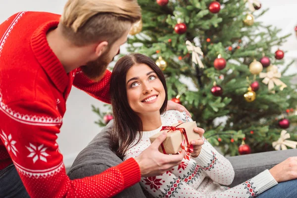 Man presenting christmas gift to girlfriend — Stock Photo, Image