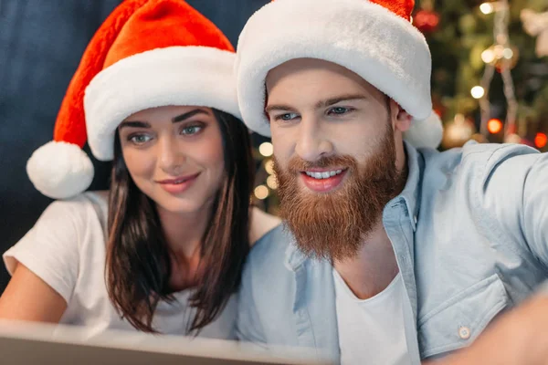 Jovem casal em chapéus de Santa — Fotografia de Stock
