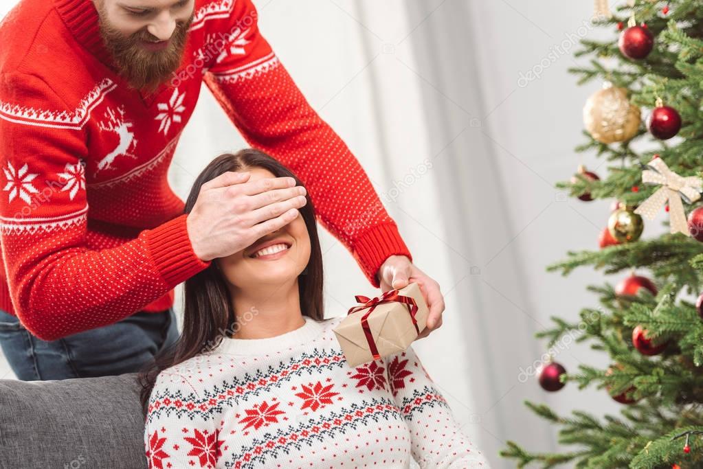 man presenting christmas gift to girlfriend