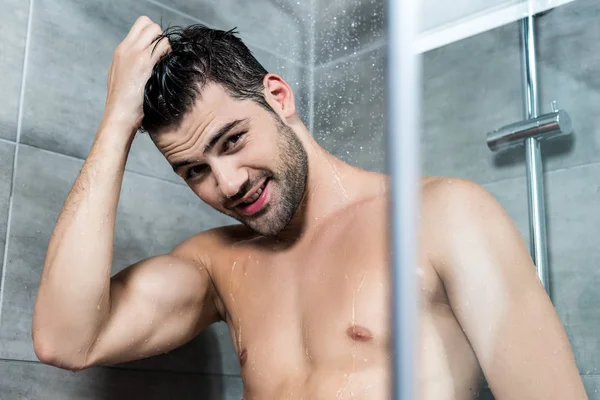 Jeune homme prenant une douche — Photo