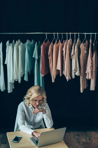 Dizüstü giyim mağazasında kullanarak iş kadını — Ücretsiz Stok Fotoğraf