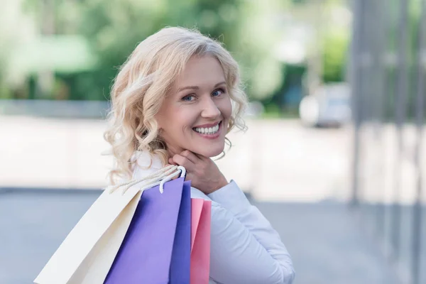 Mulher sorridente com sacos de compras — Fotografia de Stock
