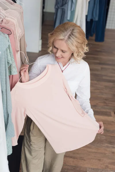 Mujer eligiendo ropa en tienda de ropa — Foto de stock gratis