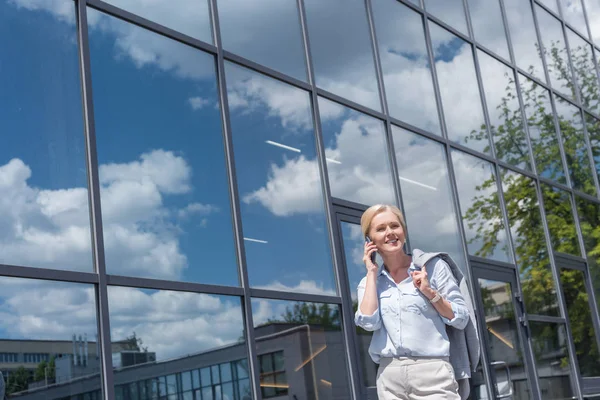 Smiling woman talking by phone — Stock Photo, Image