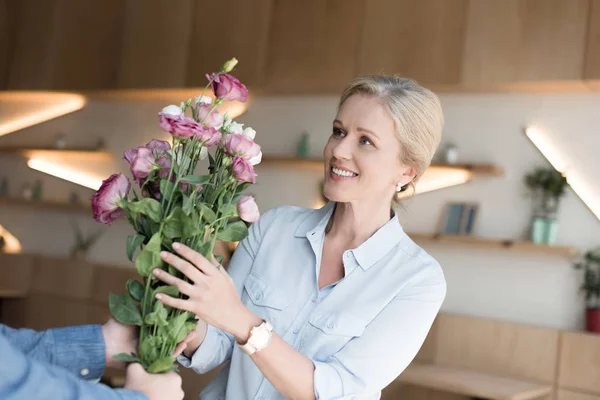 成熟した女性の花を持つ — ストック写真