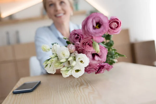 Mature woman with flowers — Stock Photo, Image