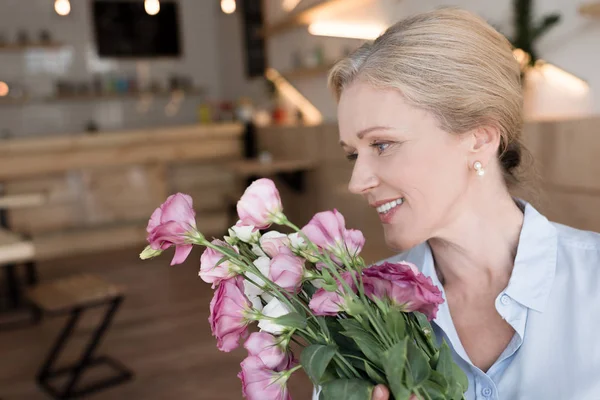 Mogen kvinna med blommor — Stockfoto