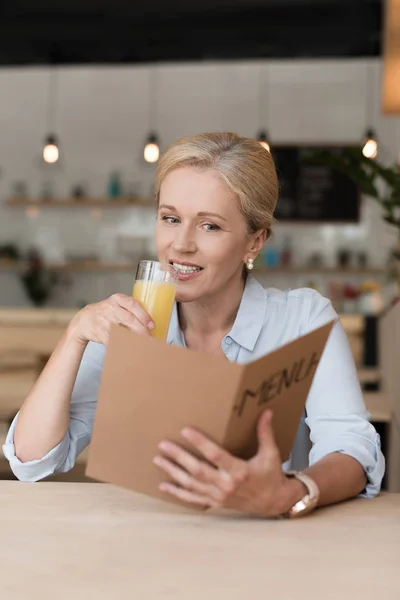 Žena čtení menu v kavárně — Stock fotografie