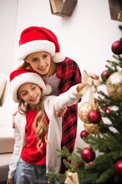 Anne ve kızı Noel ağacı süslüyorlar.
