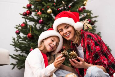 Anne ve kızı Noel ağacı süslüyorlar.