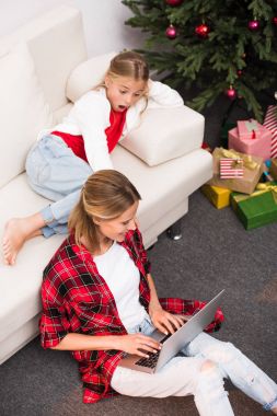 Anne ve kızı dizüstü bilgisayar kullanıyor.