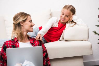 Anne ve kızı dizüstü bilgisayar kullanıyor.