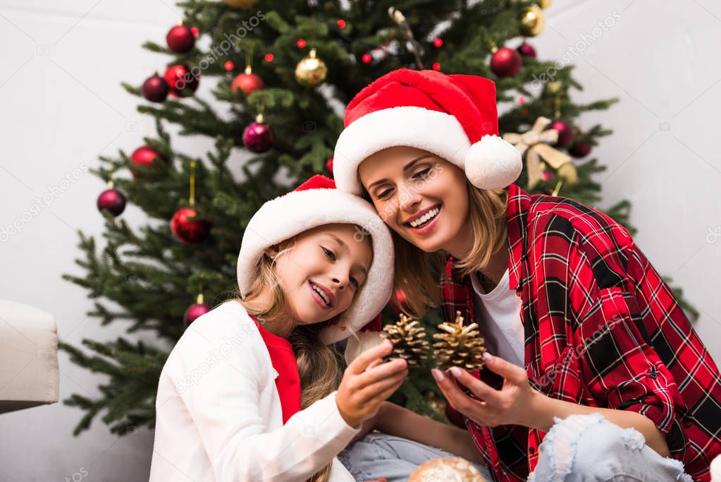 mother and daughter decorating christmas tree