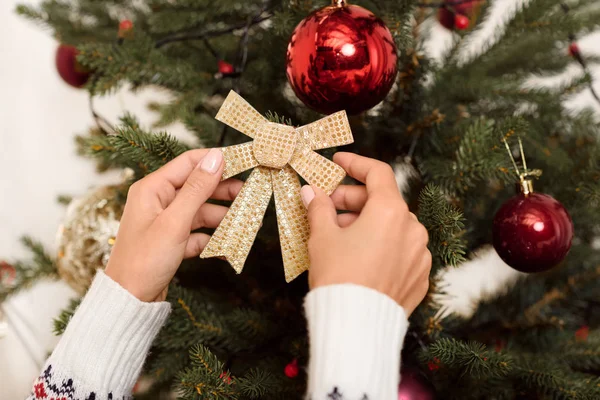 Frau schmückt Weihnachtsbaum — kostenloses Stockfoto