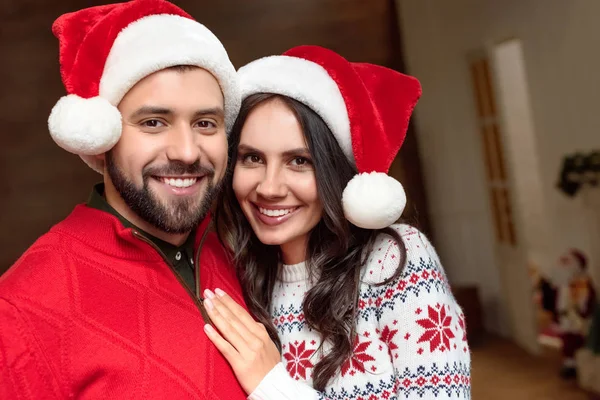 Heureux couple dans chapeaux de Père Noël — Photo