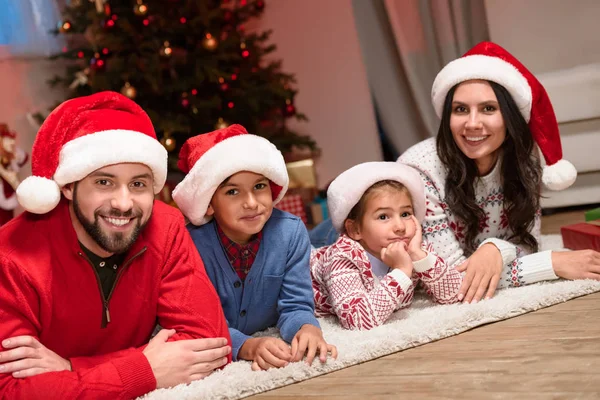 Glückliche Familie in Nikolausmützen — Stockfoto