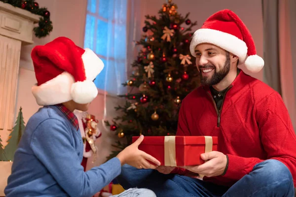 Far och son med julklapp — Stockfoto