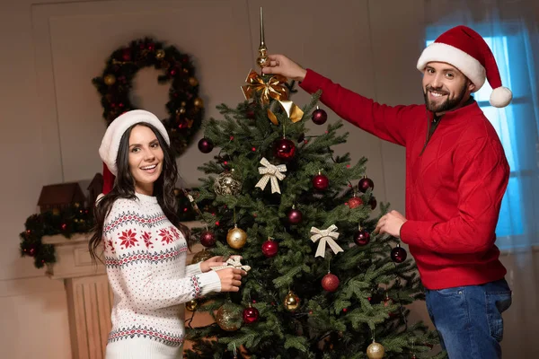 Couple decorating christmas tree — Stock Photo, Image
