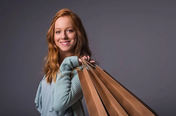 शॉपिंग बैग के साथ लाल बालों वाली लड़की — स्टॉक फ़ोटो, इमेज
