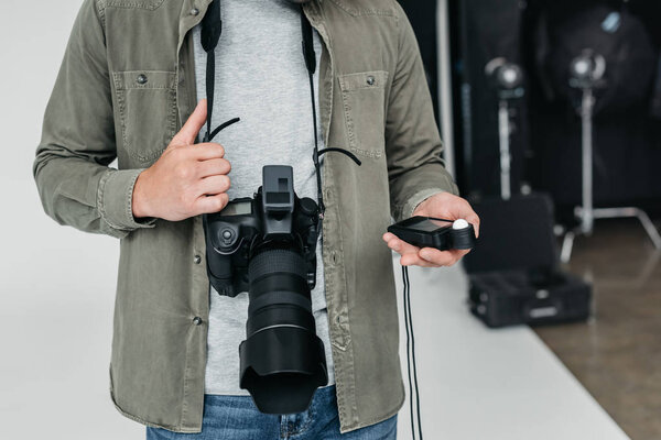 photographer with camera and light meter