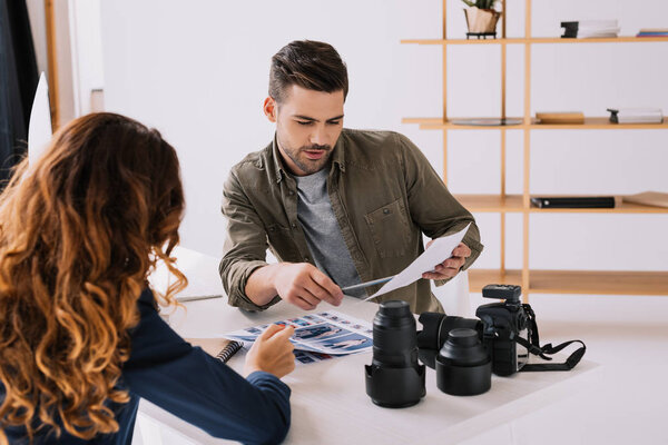 фотограф и модель, выбирающие фотографии
