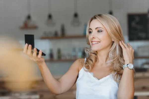 Женщина смотрит на косметическое зеркало — стоковое фото