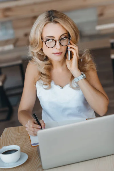 Geschäftsfrau mit Laptop und Smartphone — kostenloses Stockfoto