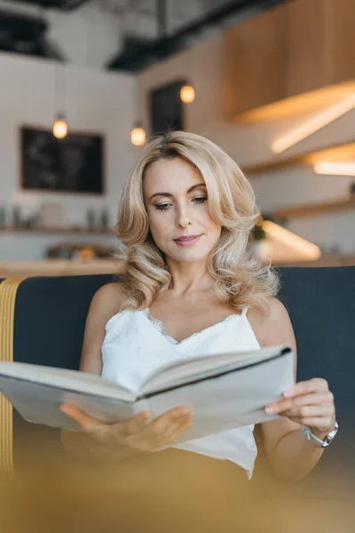 Mujer leyendo libro en la cafetería —  Fotos de Stock