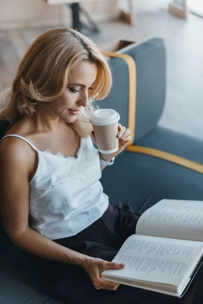 Mujer leyendo libro en la cafetería — Foto de Stock