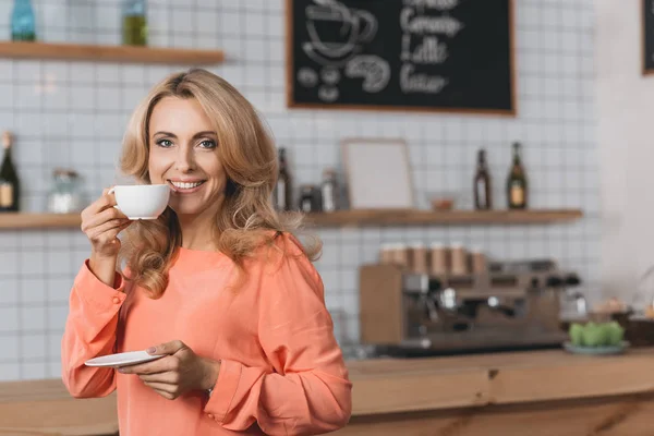 Усміхнена жінка п'є каву — стокове фото