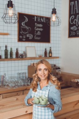 Garson holding plaka tatlı ile