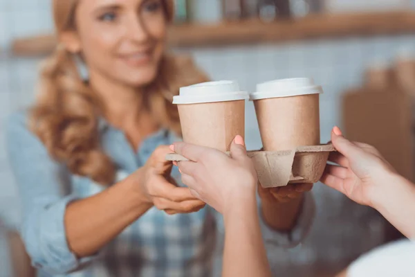Serveerster holding wegwerp koffie kopjes — Stockfoto